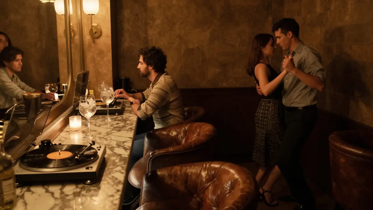 Une salle intime avec des fauteuils en cuir et un bar en marbre, où des personnes dansent doucement sous une lumière tamisée.
